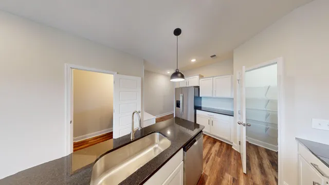 a open kitchen with a sink and a refrigerator