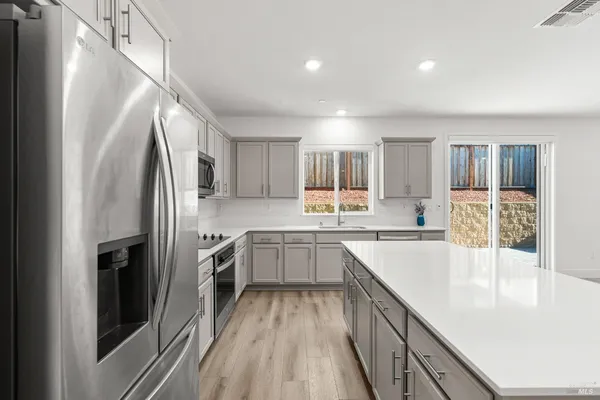 a kitchen with white cabinets and stainless steel appliances