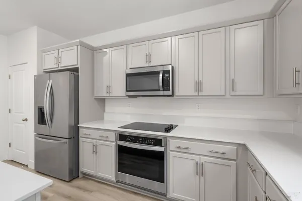 a kitchen with white cabinets and stainless steel appliances