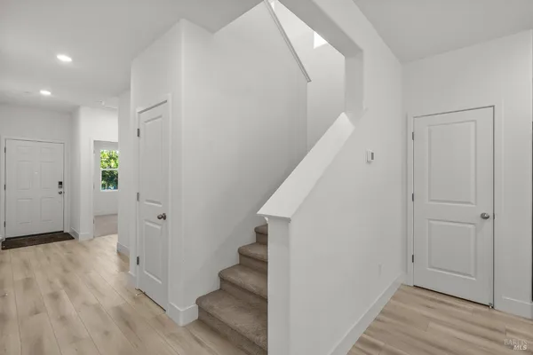 a view of a hallway with wooden floor and entryway