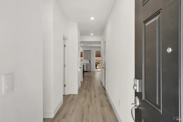 a view of a hallway with wooden floor and staircase