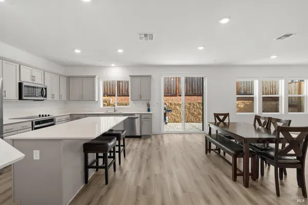 a kitchen with granite countertop kitchen island wooden floor and stainless steel appliances