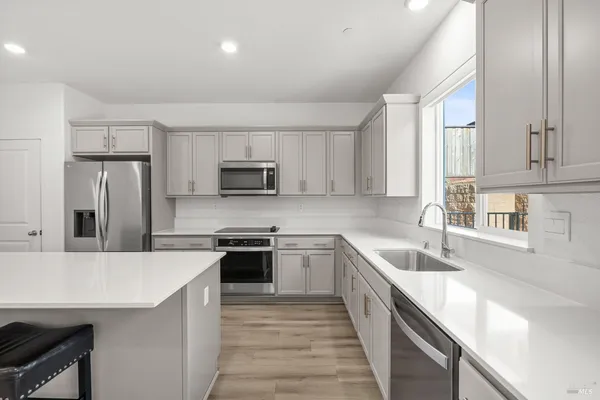 a kitchen with stainless steel appliances granite countertop a sink stove microwave and refrigerator