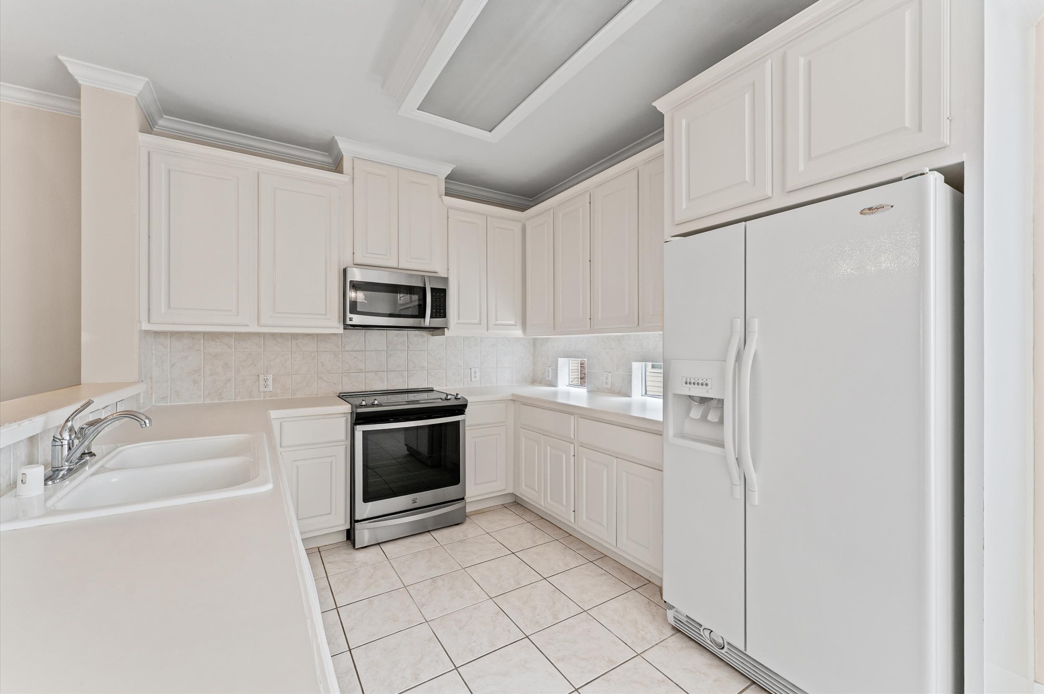 2905 Crawford Street Houston, TX 77004 - Photo 7 of 28 a kitchen with white cabinets and stainless steel appliances