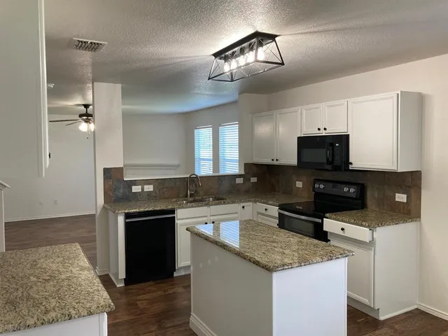 a kitchen with a sink and stainless steel appliances