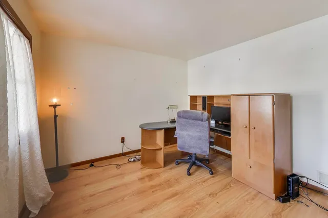 a view of a workspace with furniture and a window