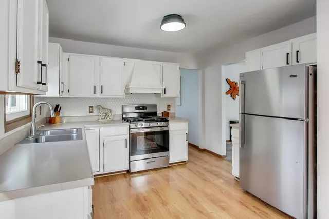 a kitchen with stainless steel appliances granite countertop a refrigerator sink and stove