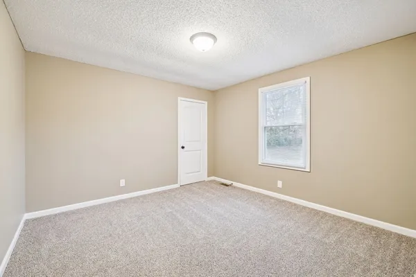 an empty room with windows and closet