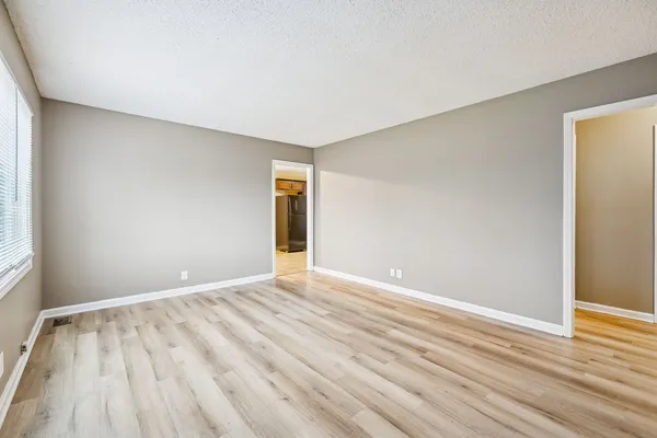 a view of an empty room with wooden floor