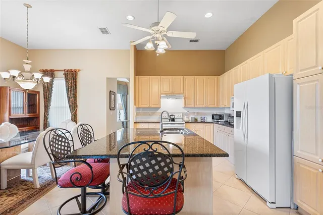 a kitchen with stainless steel appliances granite countertop a stove a refrigerator and a dining table view