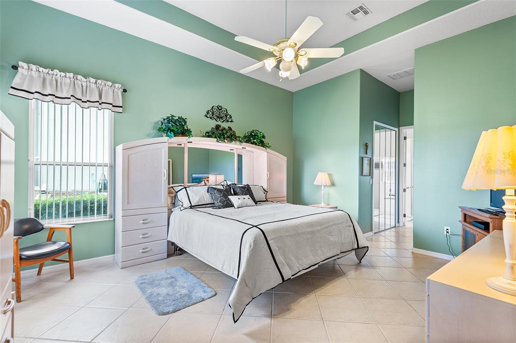 2817 Falcon Ridge Clermont, FL 34711 - Photo 21 of 41 a bedroom with a bed a chandelier and a window