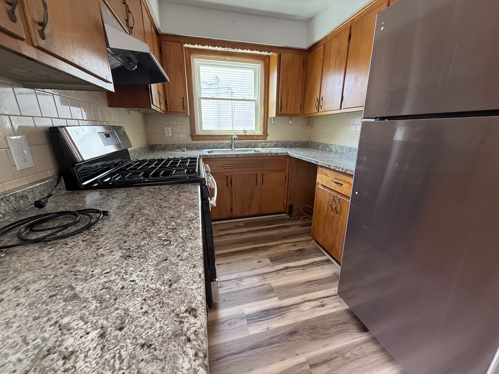 631 Walnut Street, Unit 1 Fall River, MA 02720 - Photo 3 of 12 a kitchen with a refrigerator and a stove