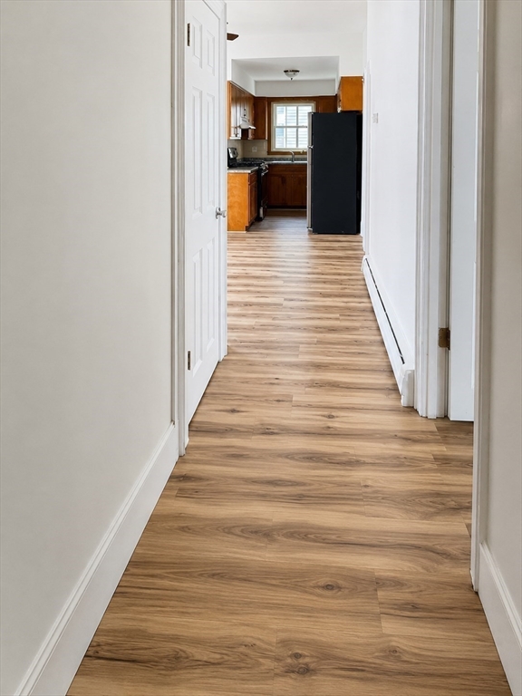 631 Walnut Street, Unit 1 Fall River, MA 02720 - Photo 6 of 12 a view of a hallway with wooden floor and furniture