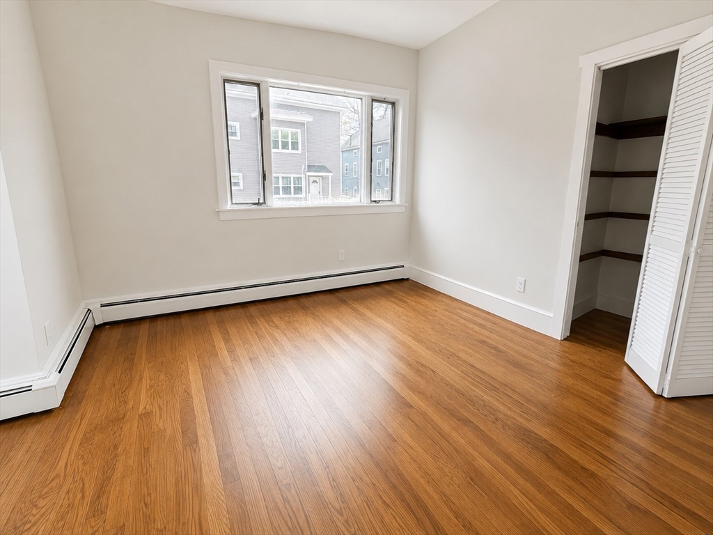 631 Walnut Street, Unit 1 Fall River, MA 02720 - Photo 7 of 12 an empty room with wooden floor and windows