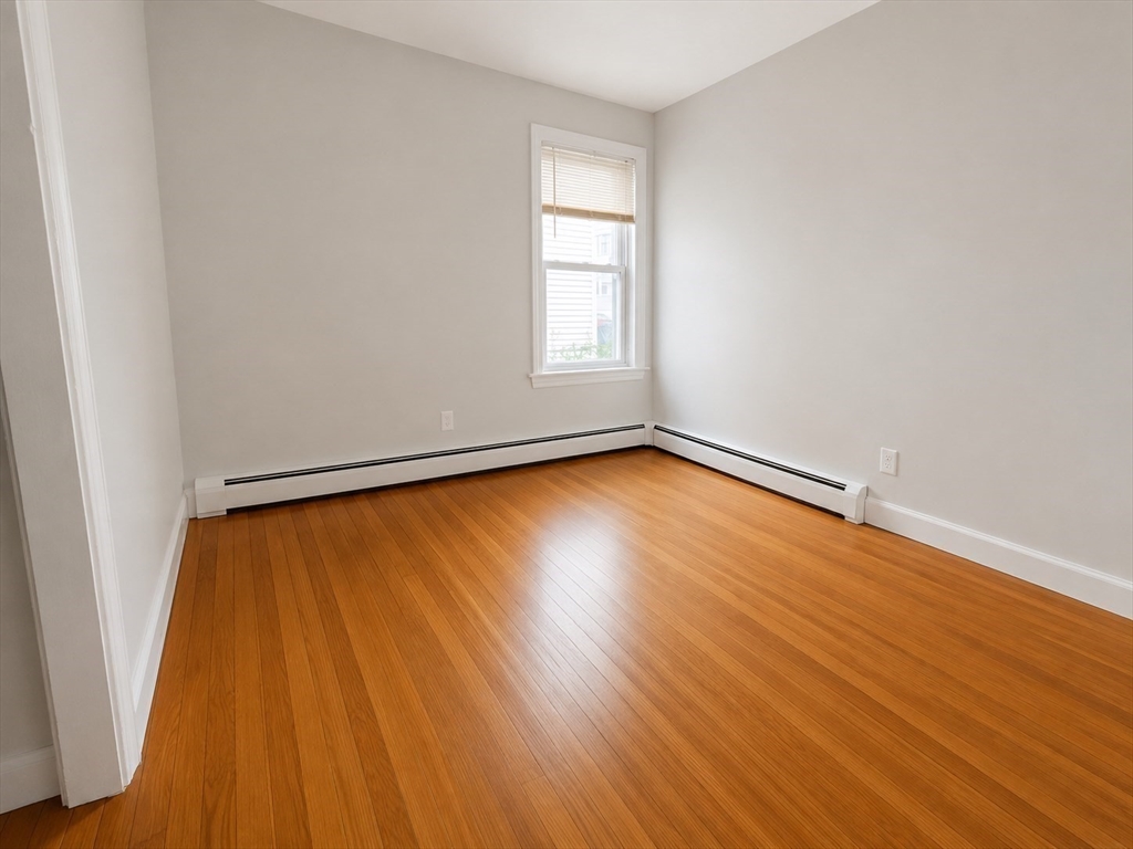 631 Walnut Street, Unit 1 Fall River, MA 02720 - Photo 10 of 12 an empty room with wooden floor and windows