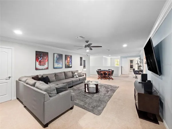 a living room with furniture a flat screen tv and kitchen view