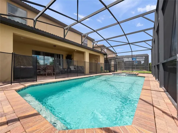 a view of a blue house with large windows and a small yard