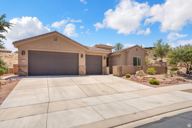 1587 Whitestone Drive St. George, UT 84790 - Photo 27 of 36 Stucco exterior featuring dual garage doors with stone accents and a concrete driveway