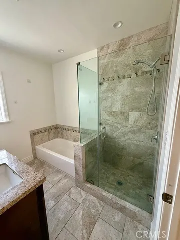 a bathroom with a granite countertop bathtub shower and sink