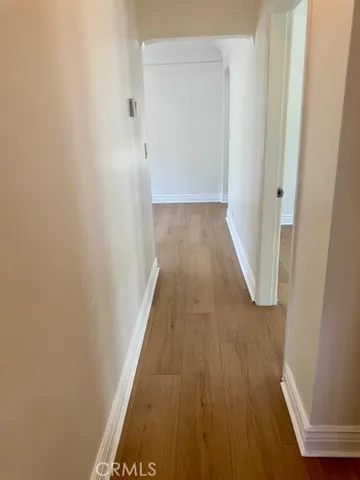 a view of a hallway with wooden floor