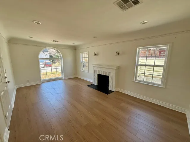 an empty room with windows and fireplace