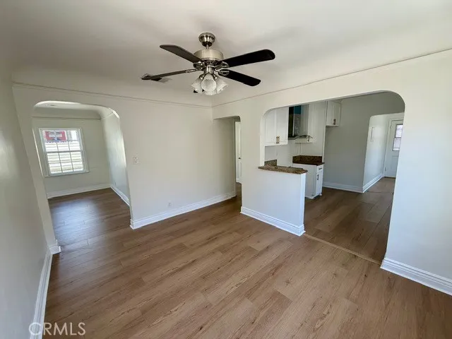 a view of a kitchen with wooden floor a sink a refrigerator and window