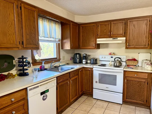 a kitchen with cabinets appliances a sink and a window