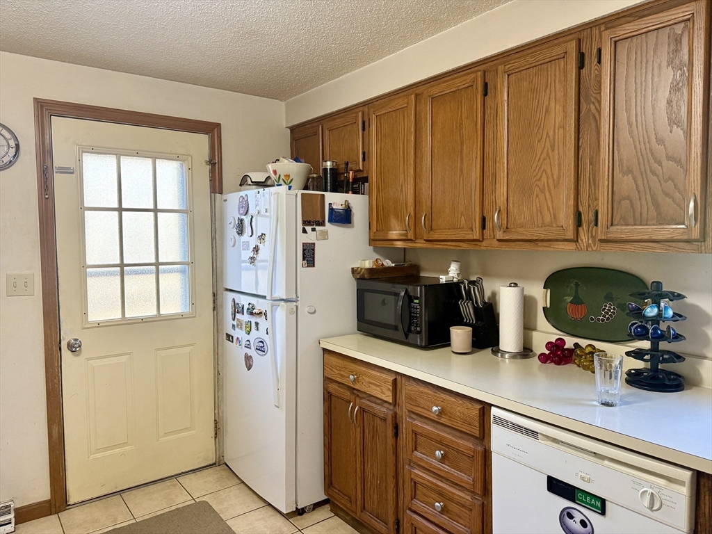567 Mendon Road, Unit 1 Attleboro, MA 02703 - Photo 4 of 12 a kitchen with stainless steel appliances granite countertop a refrigerator and cabinets