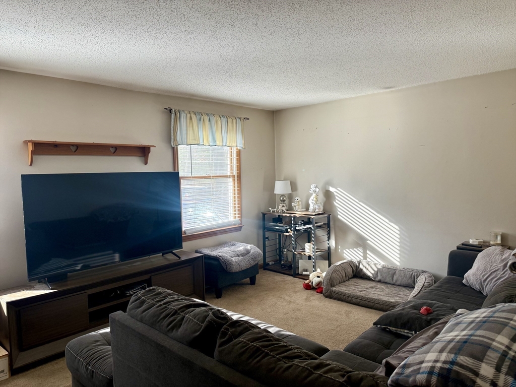 567 Mendon Road, Unit 1 Attleboro, MA 02703 - Photo 5 of 12 a living room with furniture and a flat screen tv