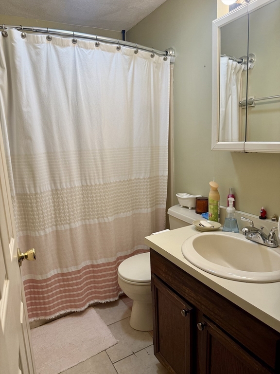 567 Mendon Road, Unit 1 Attleboro, MA 02703 - Photo 9 of 12 a bathroom with a sink a toilet and shower curtain