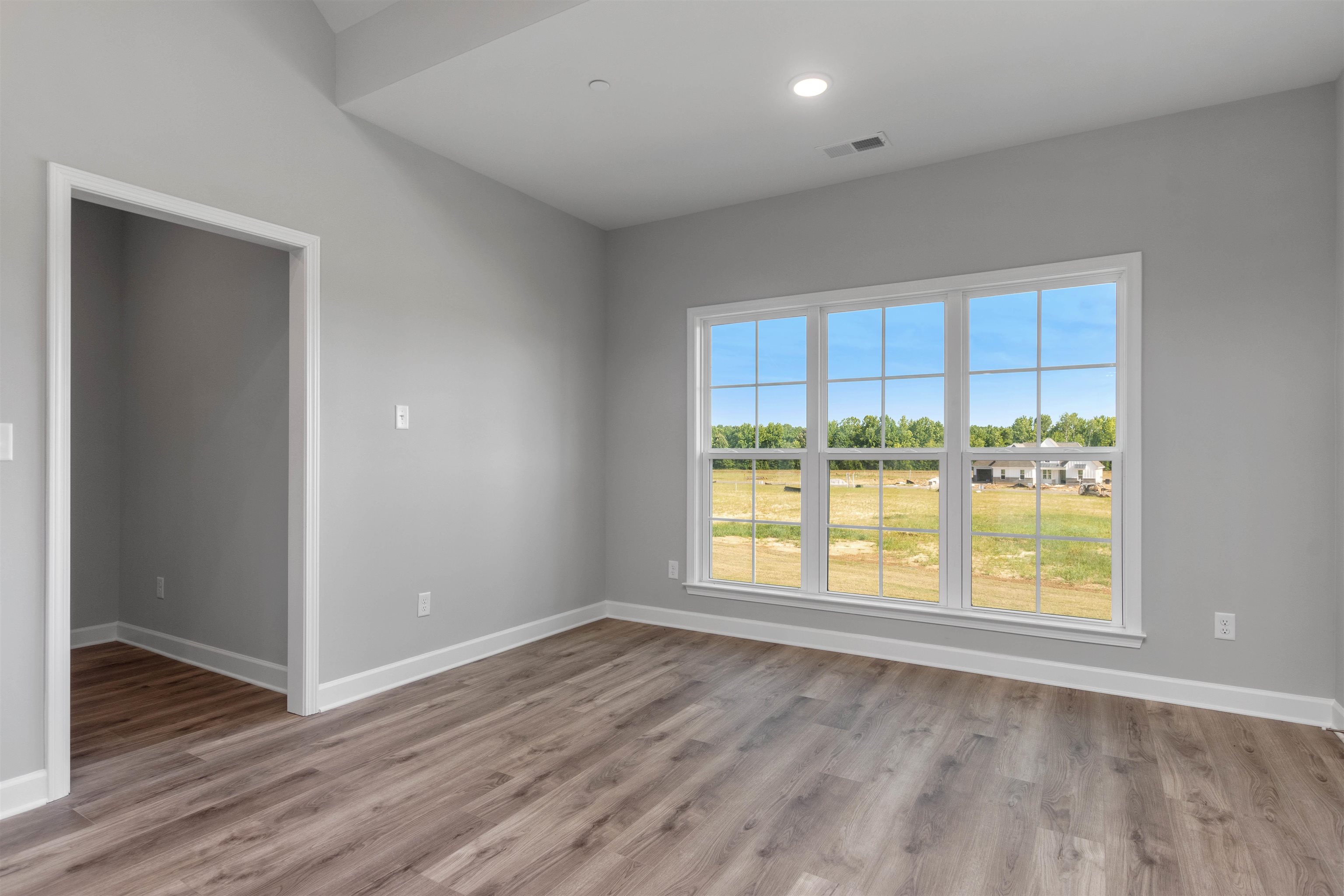20 Grassy Hill Road Collierville, TN 38017 - Photo 6 of 27 an empty room with wooden floor and windows
