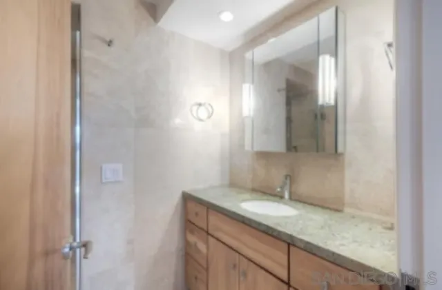 a bathroom with a granite countertop sink and mirror