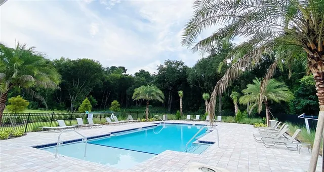 a view of a swimming pool with a lawn chairs next to yard