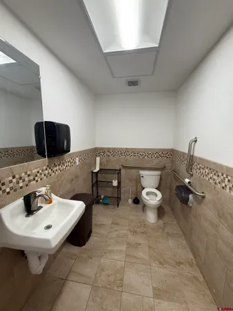 a bathroom with a toilet sink and mirror