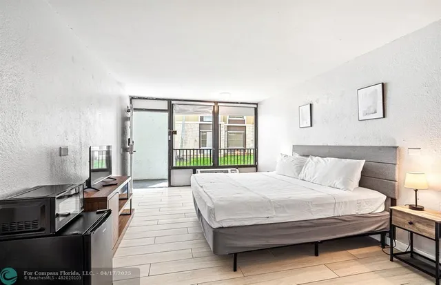 a spacious bedroom with a bed and wooden floor