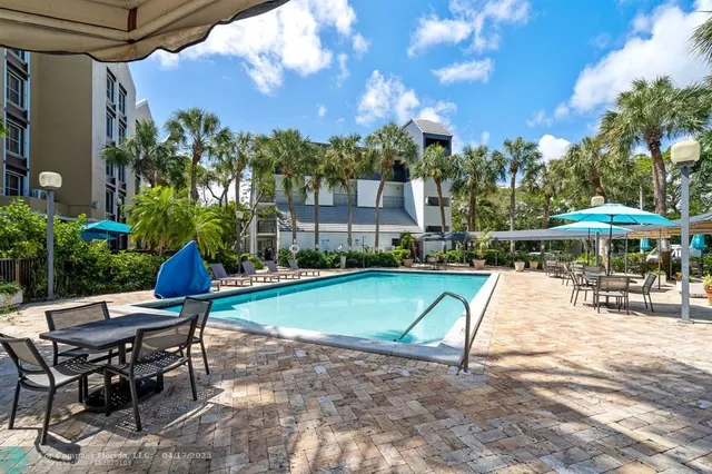 a view of a patio with a table and chairs under an umbrella
