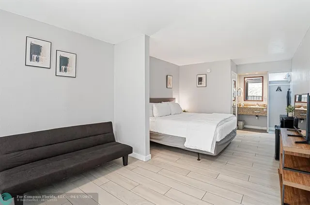 a bedroom with a bed couch and a view of living room