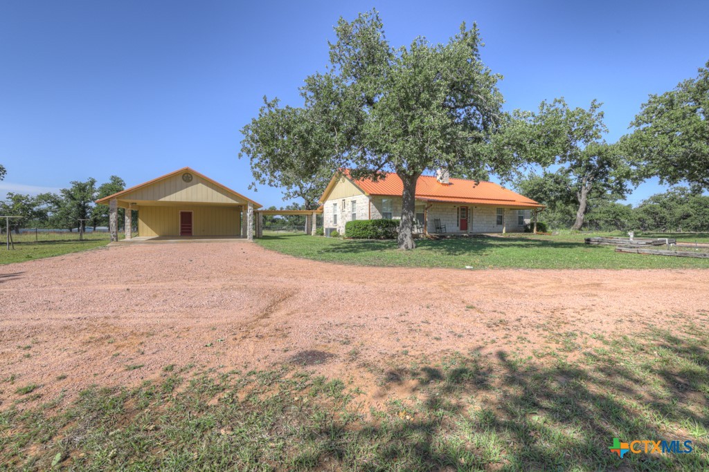 82 Bell Mountain Road Willow City, TX 78675 - Photo 5 of 41 a front view of a house with a yard and garage