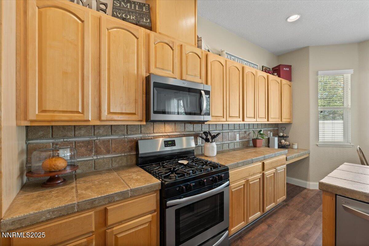 2415 Lincoln Meadows Drive Reno, NV 89521 - Photo 14 of 38 a kitchen with stainless steel appliances granite countertop a stove a sink and a microwave