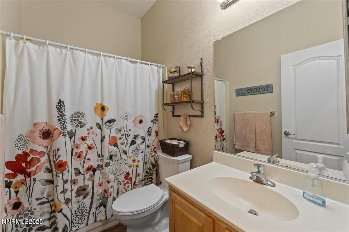 2415 Lincoln Meadows Drive Reno, NV 89521 - Photo 23 of 38 a bathroom with a toilet sink and mirror