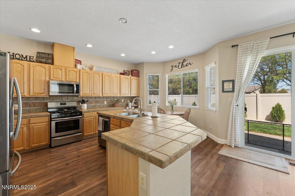 2415 Lincoln Meadows Drive Reno, NV 89521 - Photo 10 of 38 a kitchen with a stove a refrigerator and a stove top oven
