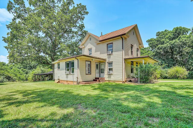 a backyard of a house with large trees and brick walls