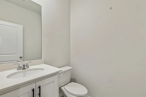 a bathroom with a sink a toilet and mirror