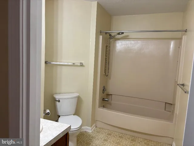 a bathroom with a shower a toilet and a bath tub