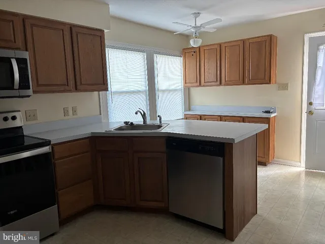 a kitchen with a sink stove top oven and cabinets