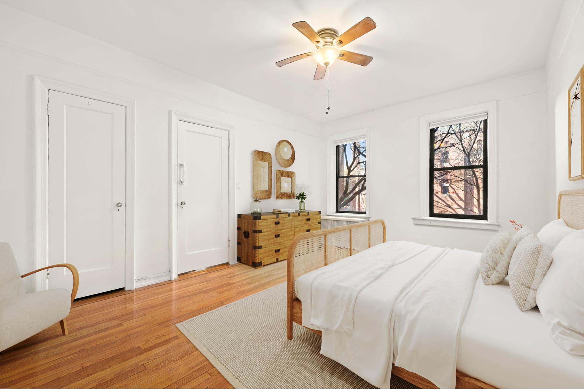 83-10 35th Avenue, Unit 2V Queens, NY 11372 - Photo 6 of 10 a bedroom with a bed and a chandelier