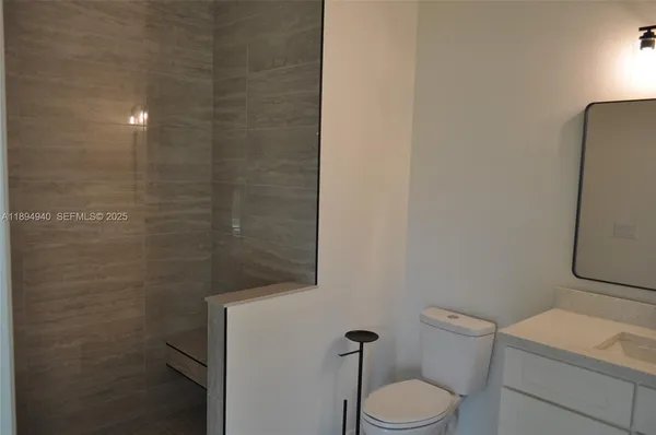 a white toilet sitting next to a shower