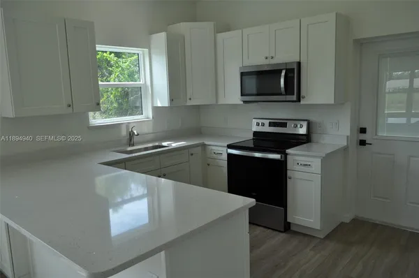 a kitchen with a stove a sink and a microwave