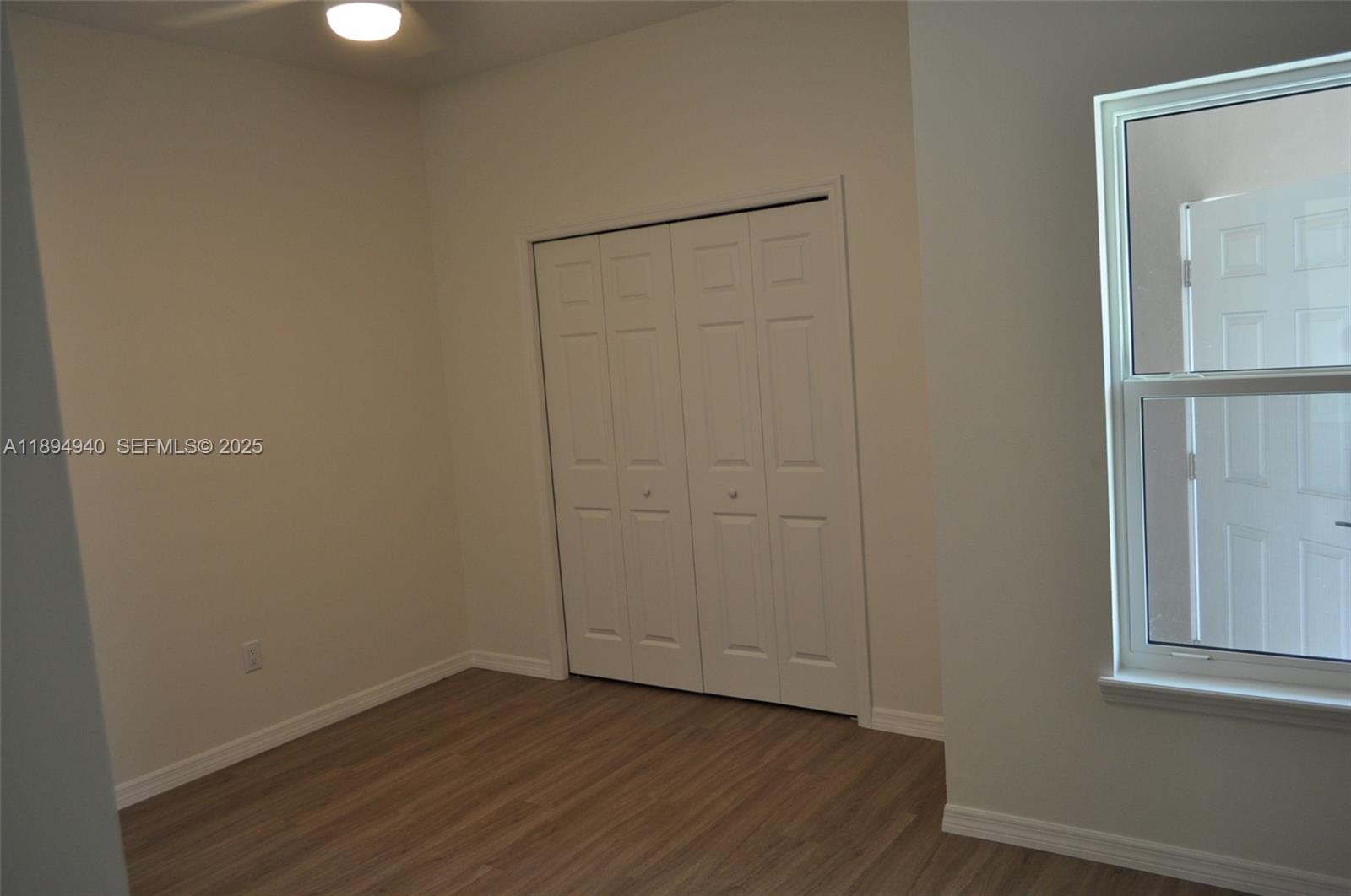 4125 Mandarin Road, Unit 4125 Sebring, FL 33875 - Photo 7 of 18 a view of an empty room with wooden floor and a window