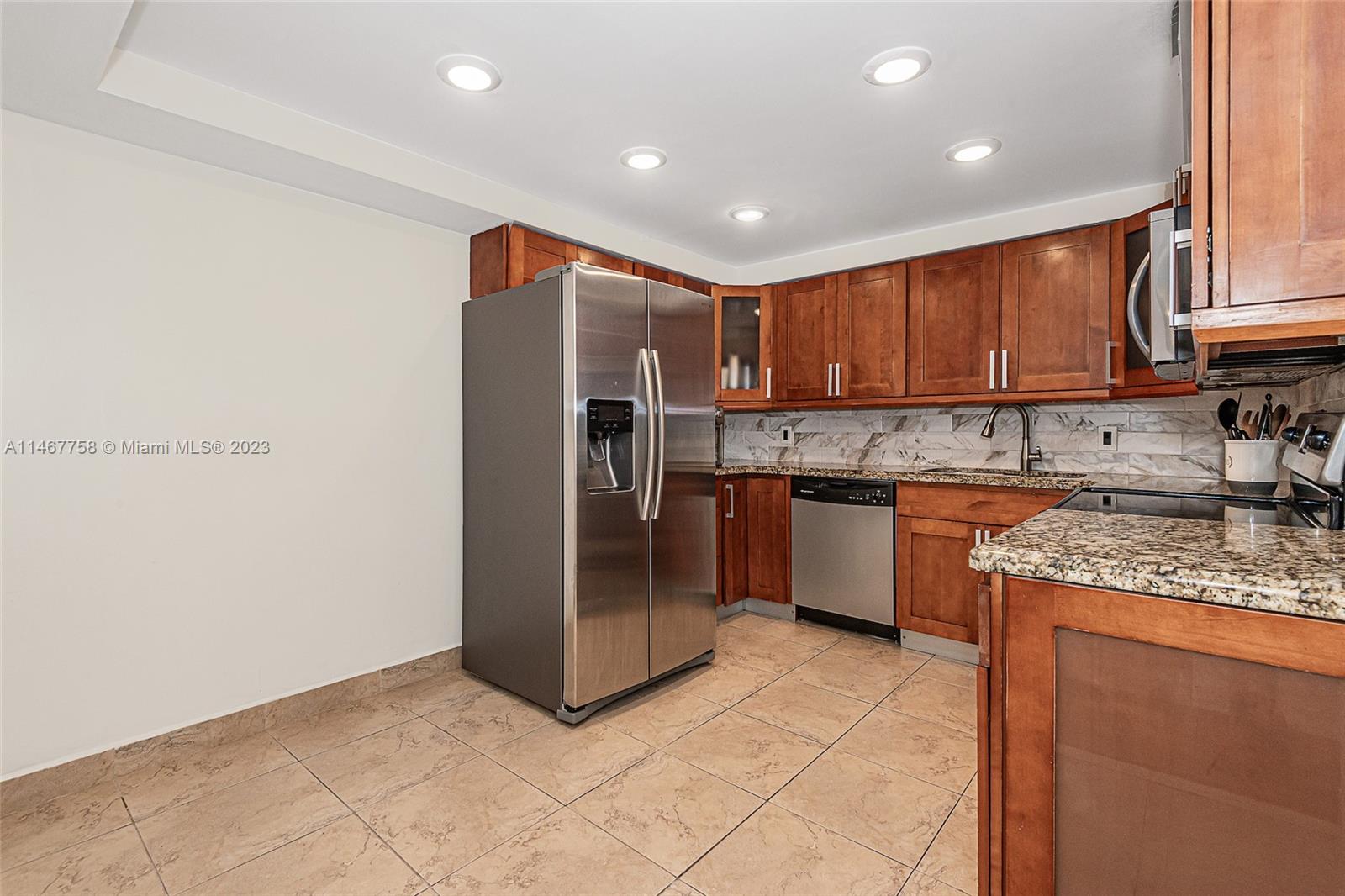 16401 Golf Club Road, Unit 311 Weston, FL 33326 - Photo 13 of 33 a kitchen with stainless steel appliances granite countertop a refrigerator and a sink